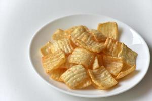 Delicious potato chips with pepper on a white plate photo