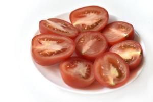 Sliced red tomato on a white plate photo