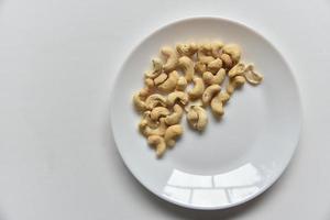 Cashew nuts on a white plate in a group of loose photo