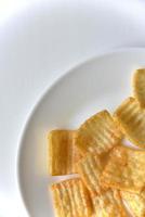 Delicious potato chips with pepper on a white plate photo