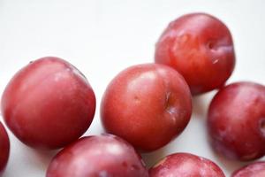 Juicy fresh red plums on a white background photo