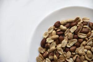 deliciosos cacahuetes fritos en un plato blanco de cerca foto