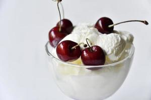 Creamy sweet ice cream in a glass ice cream maker with large cherry berries photo