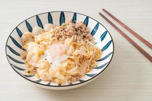 dried spicy noodles with minced pork, meatballs and egg photo