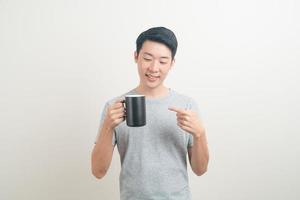 young Asian man holding coffee cup photo