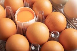 broken eggs of duck in plastic box on the wooden table photo