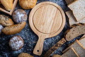 An empty wooden cutting board placed in the middle of the table photo