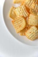 Delicious potato chips with pepper on a white plate photo