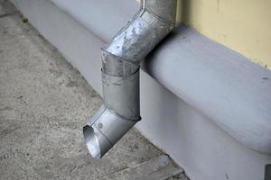 Downpipe near the wall of a house in the city photo