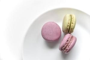 Macaroons. Sweet French desserts. Macaroons on a white plate. Macaroons on the table in the afternoon. photo