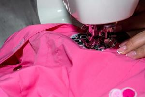 Mom sews a jacket for the child. photo