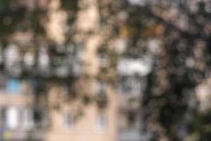 Blurred background through a mosquito net on a window made of walls, windows and leaves. City background. photo