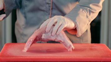 cutting raw meat with a knife close up. The chef cuts the pork into pieces for remote cooking. video