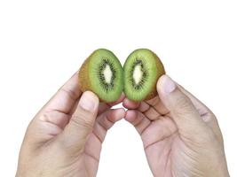 Hand holds sliced half of kiwi fruit isolated on white background photo