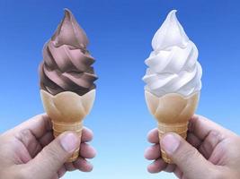 mano de hombre sosteniendo un cono de helado en el fondo. el cielo azul foto