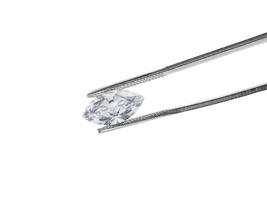 brilliant cut diamond held by tweezers photo