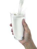 hand with glass of milk on a white background photo