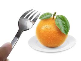 Orange fruit on dish and fork isolated on white background photo