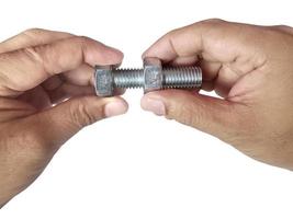 Nut and screw on hand on white background photo