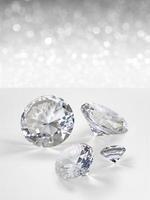 Diamonds group of placed on white shining bokeh background. concept for selection best diamond gem design photo