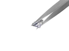 brilliant cut diamond held by tweezers photo