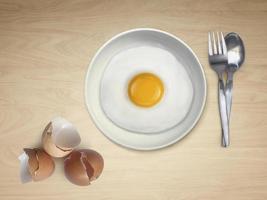 spoon fork fried egg on plate on a Wooden floor background photo