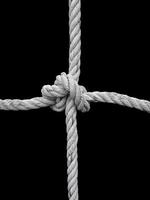 Rope knot on black background. Concept for unity photo