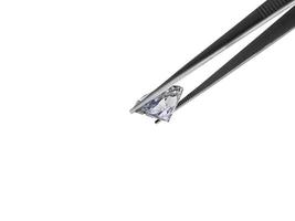 brilliant cut diamond held by tweezers photo