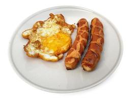 fried egg on a plate with sausage on a white background photo