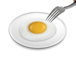 A man's hand holds a fork. fried egg on the plate a isolated white background photo