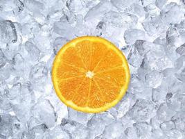 Fresh orange on ice cubes background photo