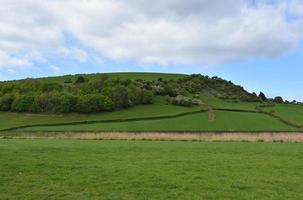 colinas y tierras de cultivo y muros de piedra en inglaterra foto