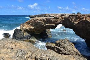 puente de roca de lava con arco natural en la costa foto