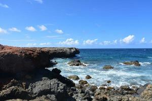 Black Lava Rock with Waves Coming Ashore in Aruba photo
