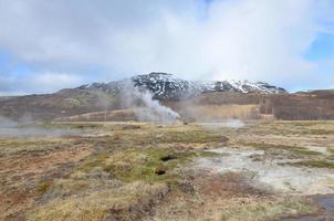 A field in Iceland with hot spring geysirs photo