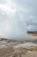 Géiser en erupción en Islandia en un día nublado foto