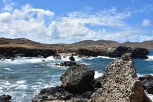 rocas de lava en la playa de piedra negra en aruba foto