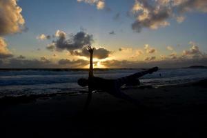 Silhouetted Side Plank on Beach at Sunrise photo