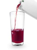 the flow of pomegranate juice being poured from box into glass isolated on white background photo