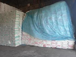 The product stock is packed in sacks, stacked in the warehouse, waiting for delivery. photo