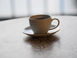 smoke on Black coffee in a white cup placed on a wooden table photo