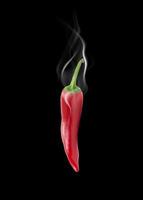 hot pepper with smoke on black background photo