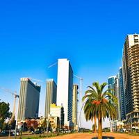 Batumi, Georgia, 2021 - Static time lapse Batumi city panorama with cars in traffic and real estate construction site with cranes in sunny day. Construction work real estate development concept photo