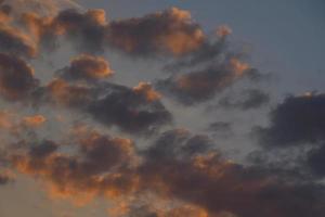 Bight dynamic cumulus clouds background blank space with passing blue rain clouds on sunset photo