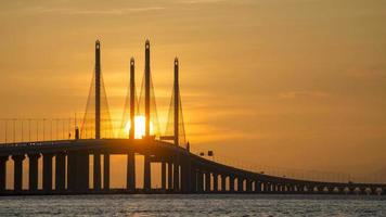 Timelapse egg yolk sunrise over silhouette Bridge. video