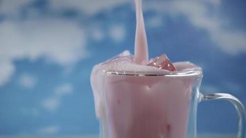 Close up double glass cup with pouring motion of  pastel pink color drink with blue sky background, pastel theme photo
