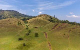 montaña calva o phu khao ya con campo de hierba verde y cielo azul. una de las atracciones turísticas naturales en la provincia de ranong, tailandia foto