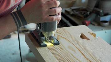woodworker carving a dovetail eyelet with a jigsaw