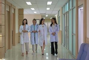 Four doctors discussing diagnosis while walking in hospital photo