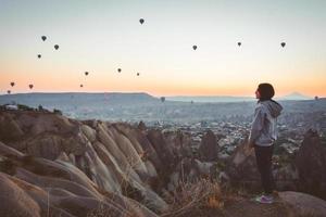 Young attractive girl stand on edge enjoy cappadocia panorama on holiday photo